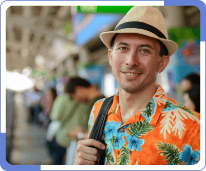 A man at a train station wearing his summer Hawaiian outfit