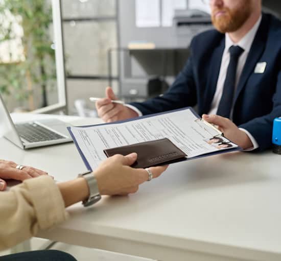 a male advisor helping a lady get her Cuban Visa forms filled out.